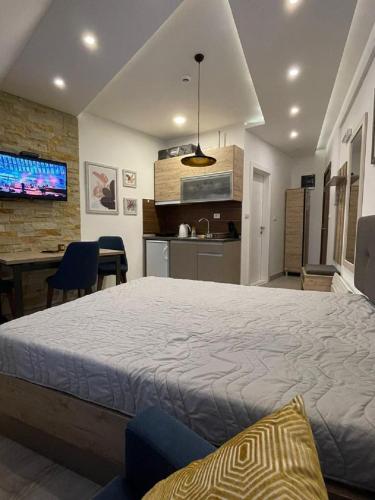 a bedroom with a large bed and a kitchen at Lola apartman Milmari & Residence Hill in Kopaonik