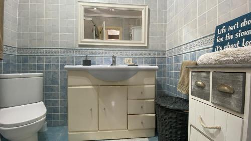 uma casa de banho com um WC, um lavatório e um espelho. em Oasis in Los Cristianos By Deihu Experiences em Arona