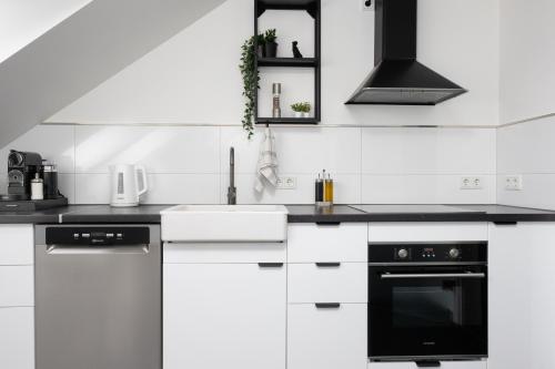uma cozinha branca com electrodomésticos a preto e branco em Lichterfüllte Erholungsoase für Groß und Klein em Schwerte