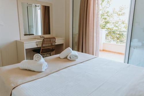 a hotel room with a bed with towels on it at Apartments Villa Rania in Perdika