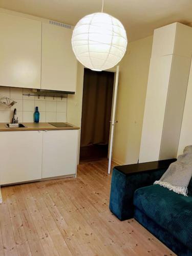 a living room with a couch and a kitchen at Nice two room flat 15 minutes from Stockholm C . in Huddinge