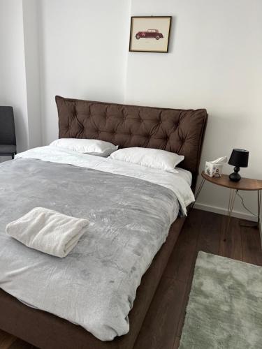 uma cama grande com lençóis brancos e almofadas em Penthouse Centar em Novi Pazar