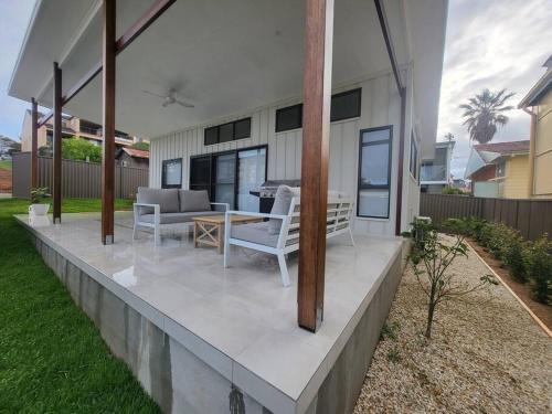 een patio met een tafel en stoelen op een huis bij Coastal Pod in Port Macquarie