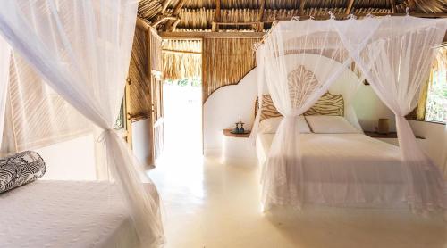 1 dormitorio con 1 cama con mosquiteras en Playa Koralia, en Buritaca