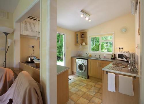 a kitchen with a sink and a washing machine at Satchwell Chalet on Reelig Estate near Inverness in Kirkhill