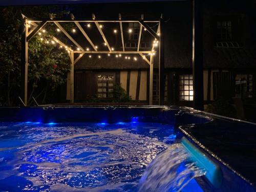 a swimming pool with blue lights and a house at chaumière familiale weekend & vacances paisible in Saint-Philbert-sur-Risle