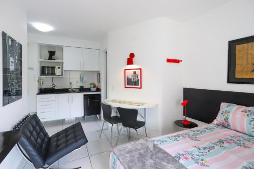 ein Schlafzimmer mit einem Bett und einem Tisch sowie eine Küche in der Unterkunft SanLoft Expo Inn Tietê 03 Top 1 in São Paulo