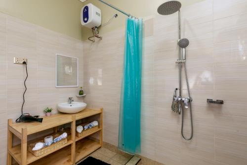 ein Bad mit einer Dusche und einem Waschbecken in der Unterkunft Delightful house Kampala Entebbe in Buzzi