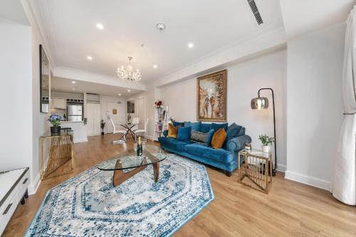 a living room with a blue couch and a table at Corporate Gem + Rooftop Pool & Spa in Auckland
