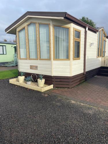 a tiny house sitting on top of a driveway at 7 Rannoch Row, lovely holiday static caravan for dogs & their owners. in Forfar