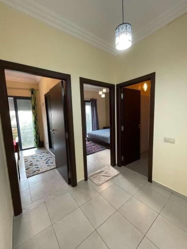 Zemmour Touirza的住宿－أكادير，走廊设有两扇门,卧室设有