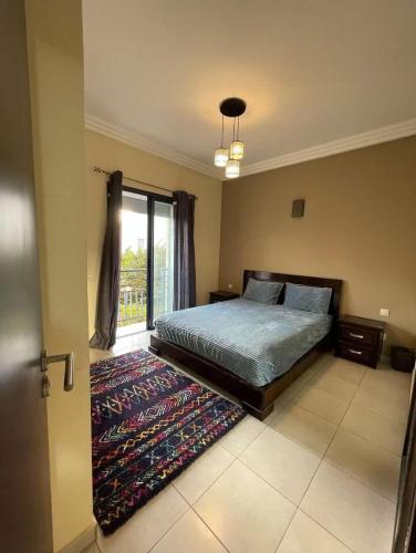 Zemmour Touirza的住宿－أكادير，一间卧室配有一张床和地毯