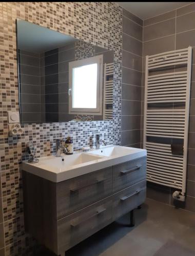 uma casa de banho com um lavatório e um espelho em Chambre spacieuse 