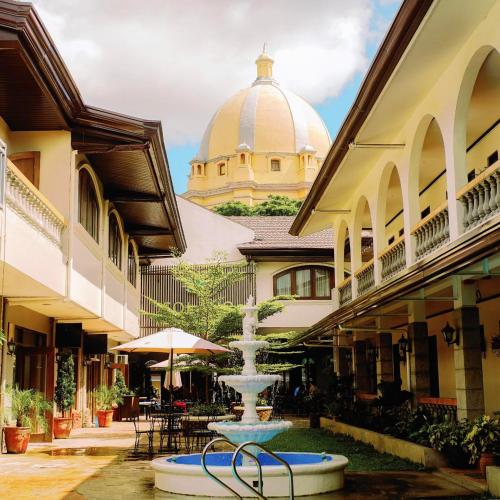 une fontaine au milieu d'une cour avec un bâtiment dans l'établissement Solano Hotel & Resort At Casa Ysabel, à Lipa