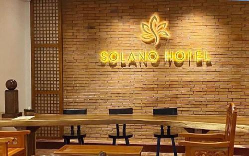 un restaurant avec une table en bois et un mur en briques dans l'établissement Solano Hotel & Resort At Casa Ysabel, à Lipa