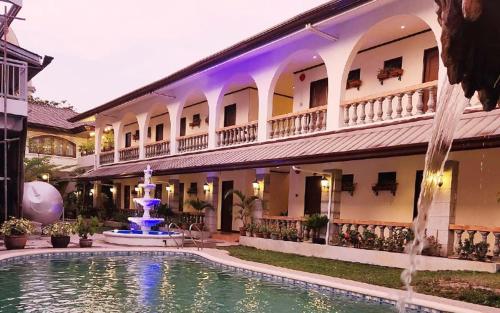 a hotel with a fountain in front of a building at Solano Hotel & Resort At Casa Ysabel in Lipa