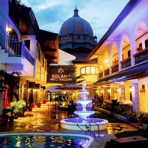 una fuente en medio de una calle con edificios en Solano Hotel & Resort At Casa Ysabel, en Lipá