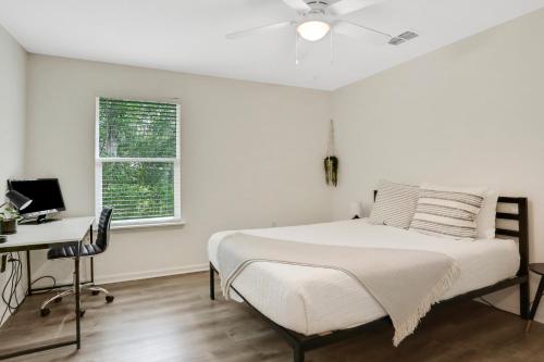 a white bedroom with a bed and a desk at Modern home with garage near town in St. Augustine