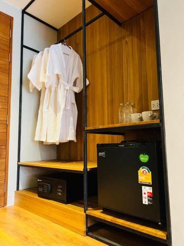 a room with a cabinet with a microwave and a shirt at Woodstory Boutique Hotel in Bangkok