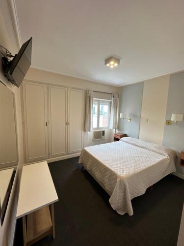 ein Schlafzimmer mit einem Bett und einem TV in der Unterkunft Hotel Miami in San Miguel de Tucumán