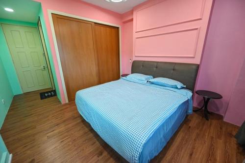 un letto in una camera con pareti rosa e verdi di Santubong Suites Lower Level a Kuching