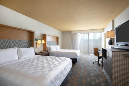 Habitación de hotel con 2 camas y TV de pantalla plana. en Holiday Inn Denver East, an IHG Hotel, en Denver