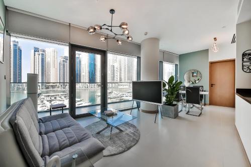 a living room with a couch and a tv at Luxurious 2BR apt with panoramic Marina view in Dubai