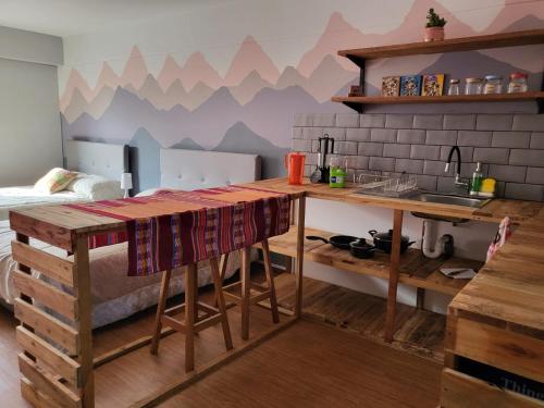 a kitchen with a table and a bed in a room at Alojamiento San Francisco - Apartamentos y habitaciones in Lima