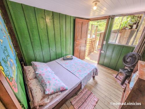 um quarto com uma cama num quarto com paredes verdes em Quarto do Madruga na Ilha do Mel