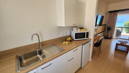 a kitchen with a sink and a microwave on a counter at Resort Tava'e in Amuri