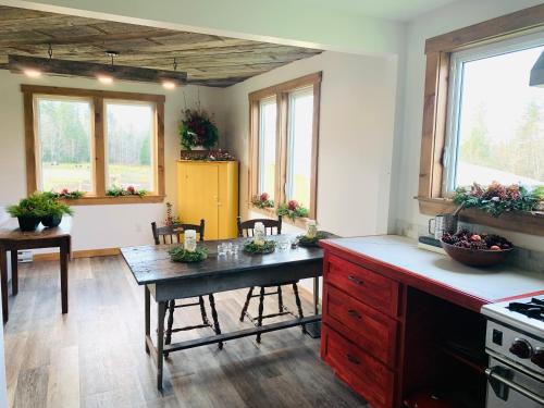 eine Küche mit einem Tisch, Stühlen und Fenstern in der Unterkunft The Galloway House in Hillsborough
