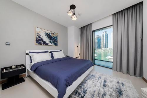 a bedroom with a bed and a large window at Luxurious 2BR apt with panoramic Marina view in Dubai