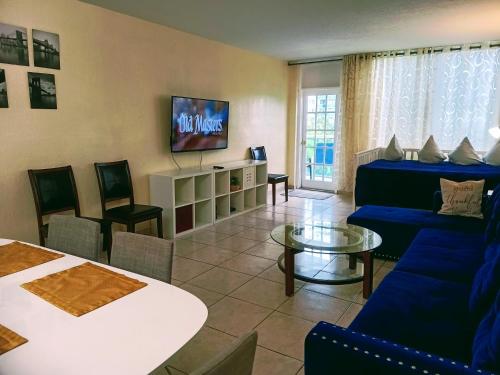 a living room with a blue couch and a tv at Ocean Reserve in Sunny Isles Beach