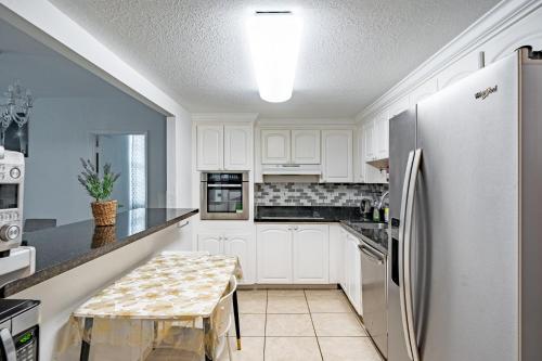 a kitchen with white cabinets and a refrigerator at Ocean Reserve in Sunny Isles Beach