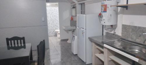 a small kitchen with white appliances and a sink at Refugio Amaicha in Embalse