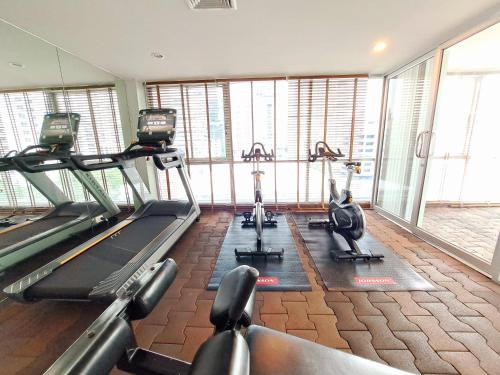 a gym with several tread machines in a room with windows at 6C-Short-term rental allowed-2BRs Downtown Bangkok in Makkasan