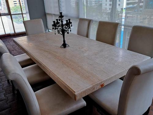 a dining room table with chairs and a wooden table with a centerpiece at 6C-Short-term rental allowed-2BRs Downtown Bangkok in Makkasan