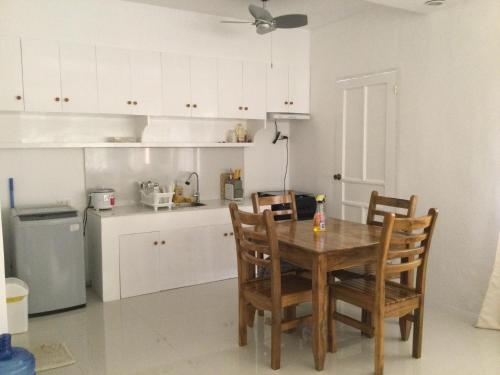 a kitchen with a wooden table and chairs in it at Gengs Apartment and Nmax Rentals in Dipolog