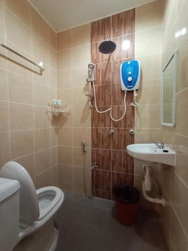 a bathroom with a shower with a toilet and a sink at Dane & Shue Hotel Kok Lanas in Kota Bharu