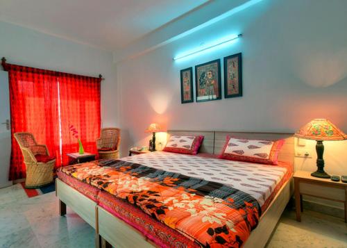 a bedroom with a bed and a red curtain at The Coral Tree Boutique Homestay in Agra