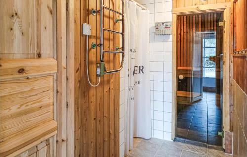baño con ducha y pared de madera en Stunning Home In Kpingsvik With Kitchen, en Köpingsvik