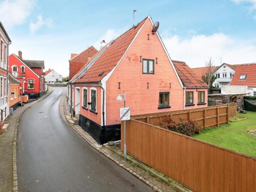 a red brick house with a fence on a street at 4 person holiday home in Marstal-By Traum in Marstal
