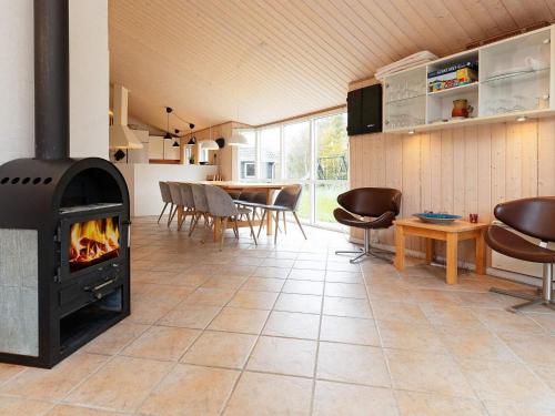 a living room with a fireplace and a dining room at 10 person holiday home in Fjerritslev-By Traum in Fjerritslev
