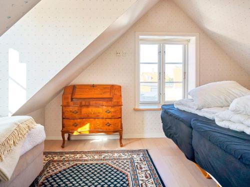 um quarto no sótão com uma cómoda e uma janela em Holiday home Rønne VI em Rønne