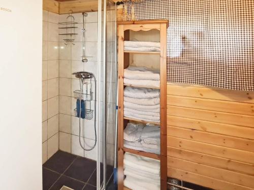 a bathroom with a shower and a rack of towels at Holiday home Tau II in Tau