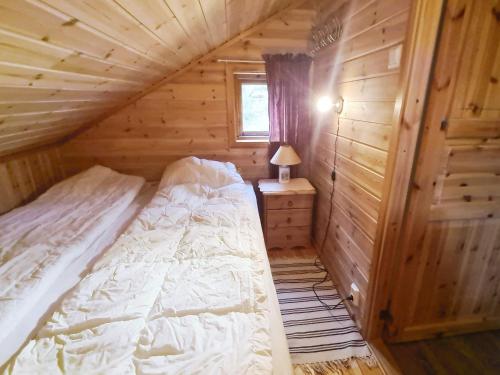 a bedroom with a bed in a wooden cabin at Holiday home Tau II in Tau