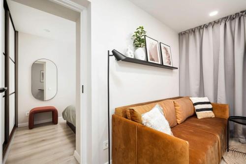 uma sala de estar com um sofá castanho e um espelho em Tyzenhauzu Apartment em Vilnius