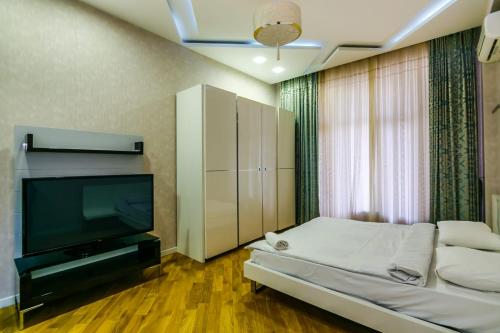 een slaapkamer met een tv en een bed en een televisie bij CENTER. 3 Bedrooms in Baku