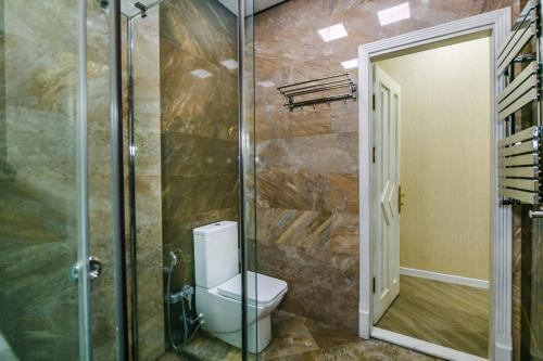 een badkamer met een toilet en een glazen douche bij CENTER. 3 Bedrooms in Baku