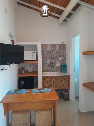 a kitchen with a wooden table in a room at Recanto da Praia Kitnetes in Caraguatatuba